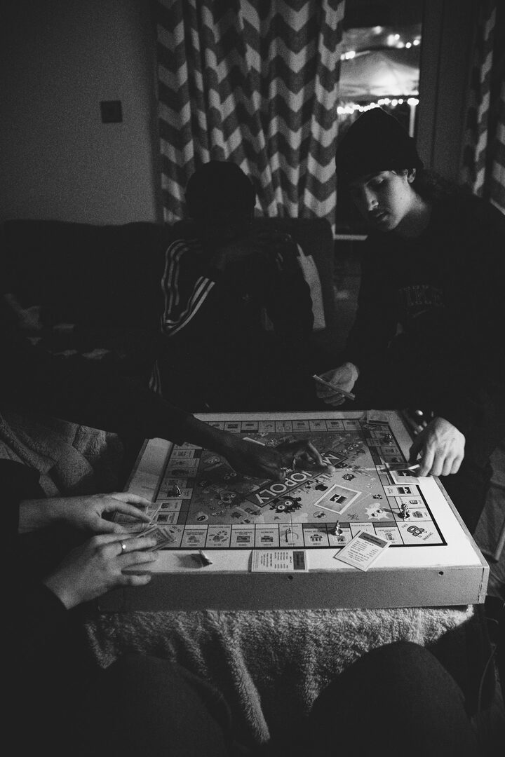 Friends playing board games by warm indoor light