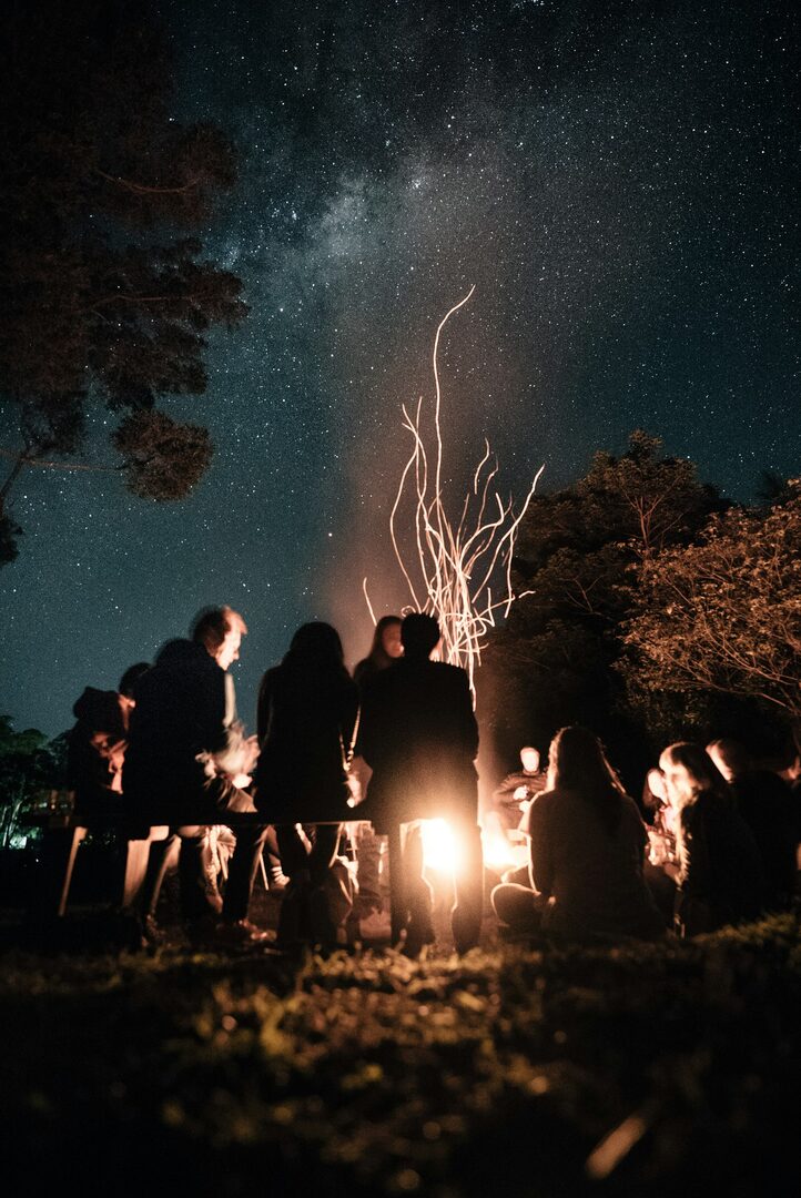 Friends around a bonfire under the Milky Way